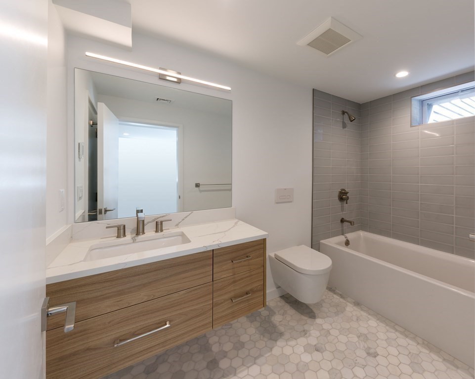 43 Ruane Road Newton, MA 02465 - Photo 23 of 24 a bathroom with a double vanity sink toilet mirror and bathtub