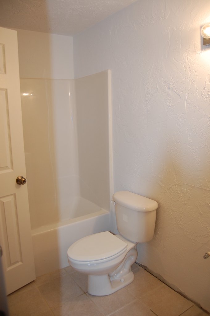 2057 Morgans Mill Road Goodview, VA 24095 - Photo 11 of 18 a white toilet sitting next to a bath tub