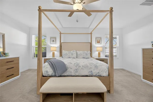 a bedroom with a large bed and a ceiling fan