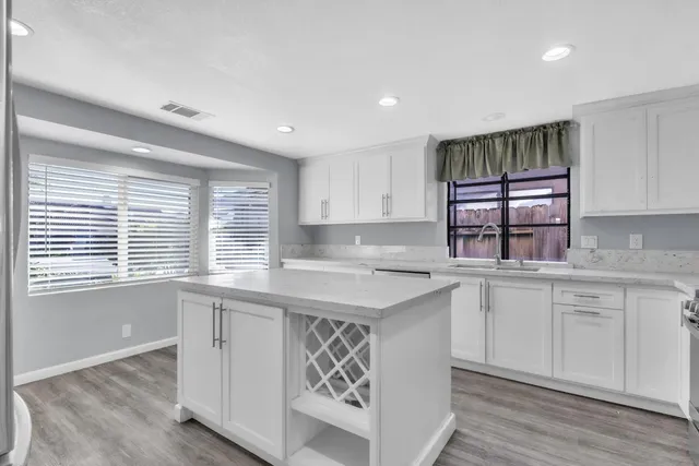 a kitchen with a sink window and cabinets
