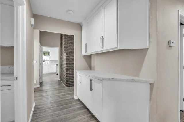 a view of a kitchen with wooden floor and cabinets