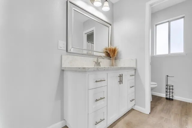 a bathroom with a granite countertop sink and a mirror