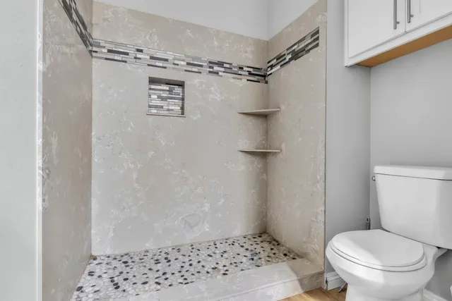 a bathroom with a shower toilet and sink