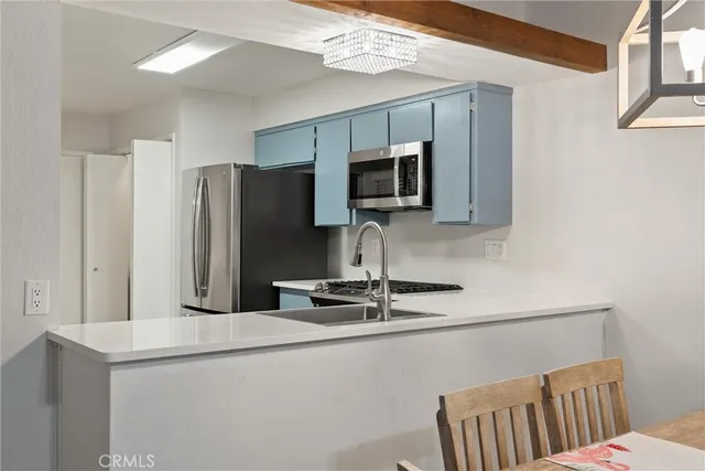 a kitchen with stainless steel appliances a refrigerator and microwave
