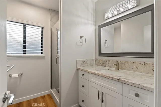 a bathroom with a granite countertop sink a mirror and a window