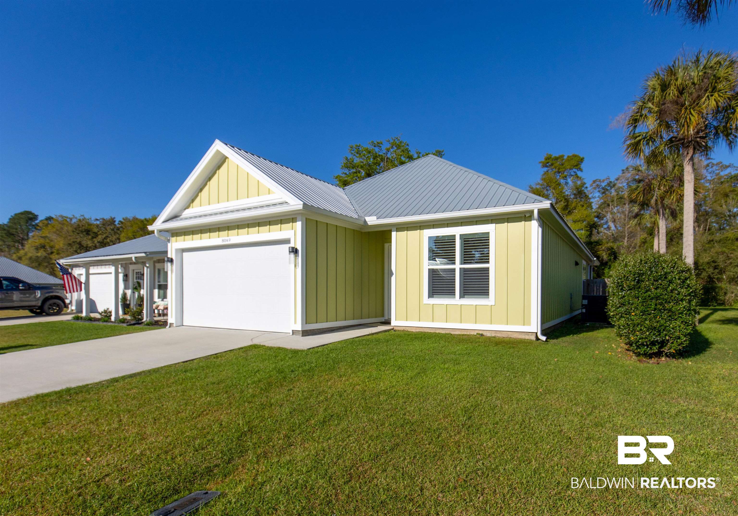 8069 Carmel Circle Foley, AL 36535 - Photo 1 of 23 View of front facade with board and batten siding, a front yard, driveway, and an attached garage