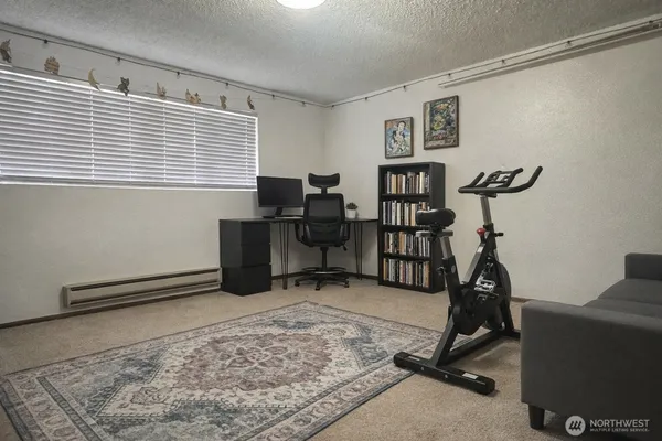 a view of a workspace with furniture and a window