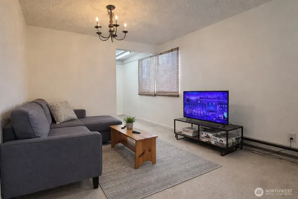 a living room with furniture a chandelier and a window