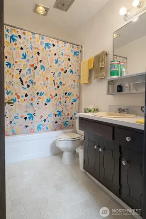 a bathroom with a sink a toilet and shower curtain