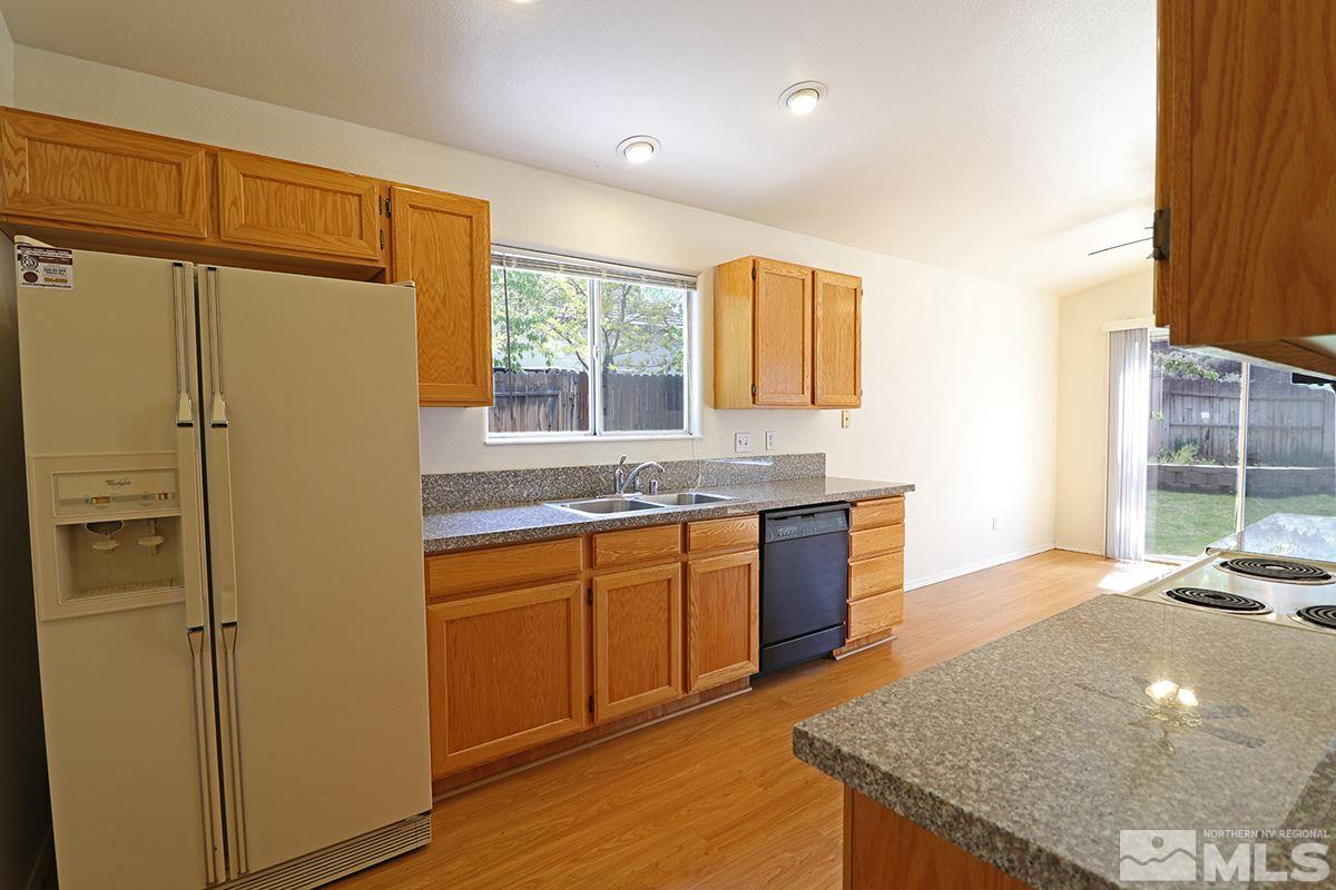 4652 Goodwin Road Sparks, NV 89436 - Photo 8 of 20 a kitchen with stainless steel appliances granite countertop a refrigerator a sink dishwasher with a dining table and chairs