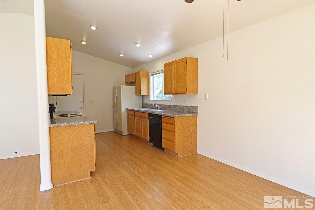 4652 Goodwin Road Sparks, NV 89436 - Photo 9 of 20 a kitchen with stainless steel appliances granite countertop a stove a sink and a refrigerator with wooden floor