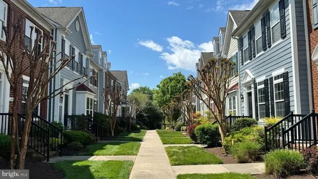 a front view of a multi story residential apartment building with yard and green space