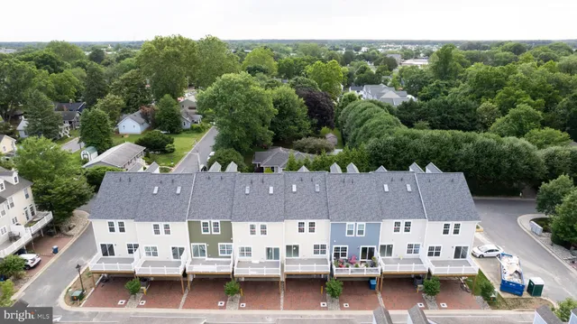 an aerial view of residential houses with outdoor space and parking