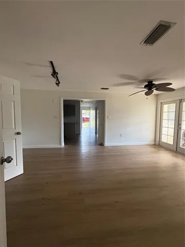 a view of empty room with wooden floor