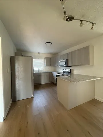 a view of a kitchen with furniture and wooden floor