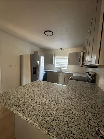 a kitchen with stainless steel appliances granite countertop a sink refrigerator and cabinets