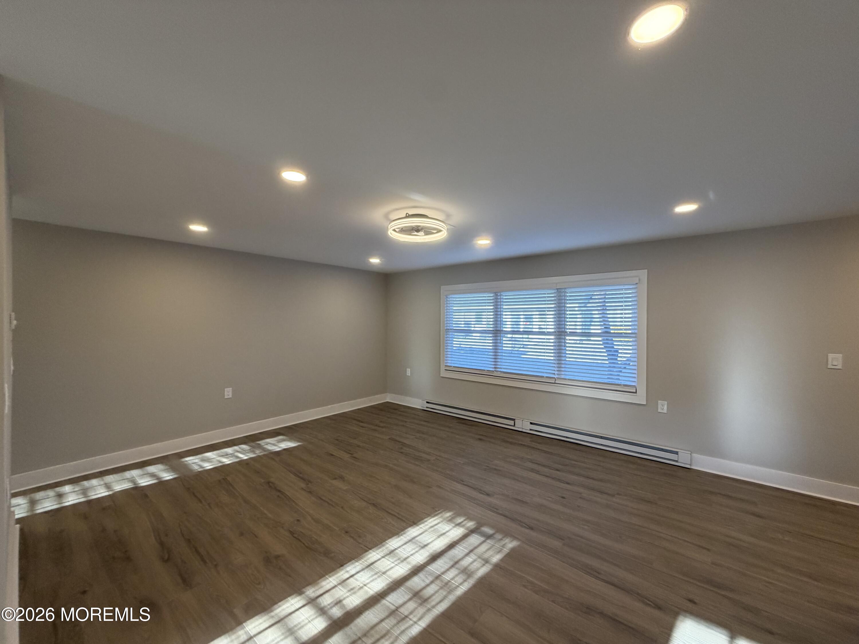833 B Inverness Court, Unit B Lakewood, NJ 08701 - Photo 11 of 43 an empty room with wooden floor and windows