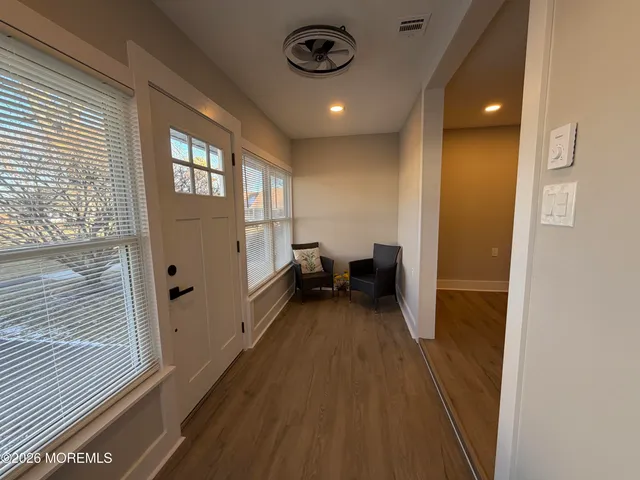 a view of a hallway and a livingroom with furniture