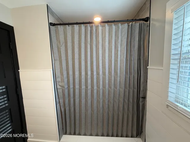 a view of a bathroom with shower curtain