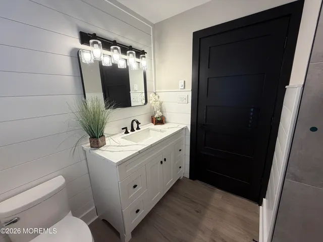 a bathroom with a sink toilet and mirror