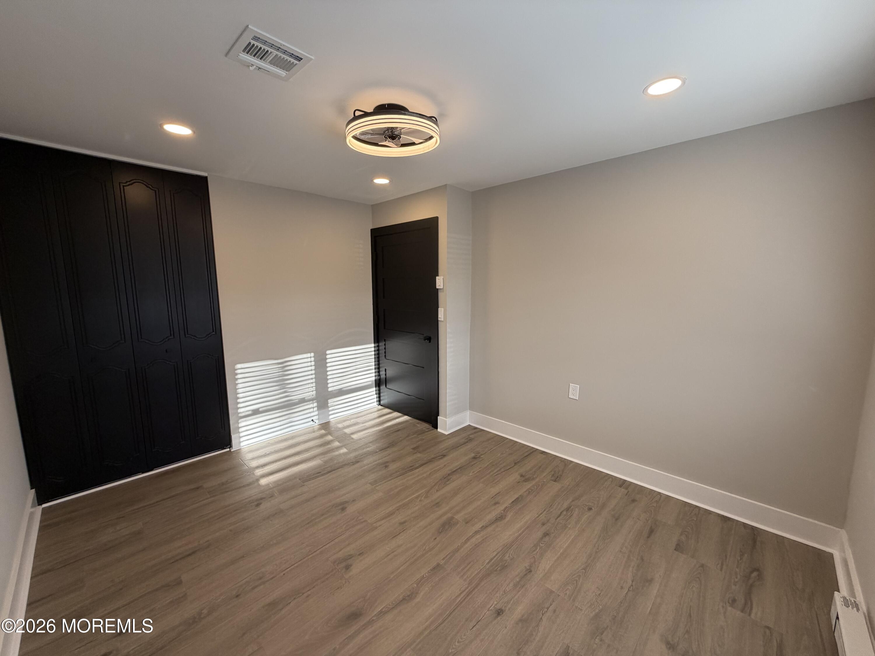 833 B Inverness Court, Unit B Lakewood, NJ 08701 - Photo 29 of 43 a view of an empty room with wooden floor