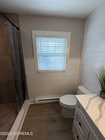 a bathroom with a granite countertop toilet and a sink
