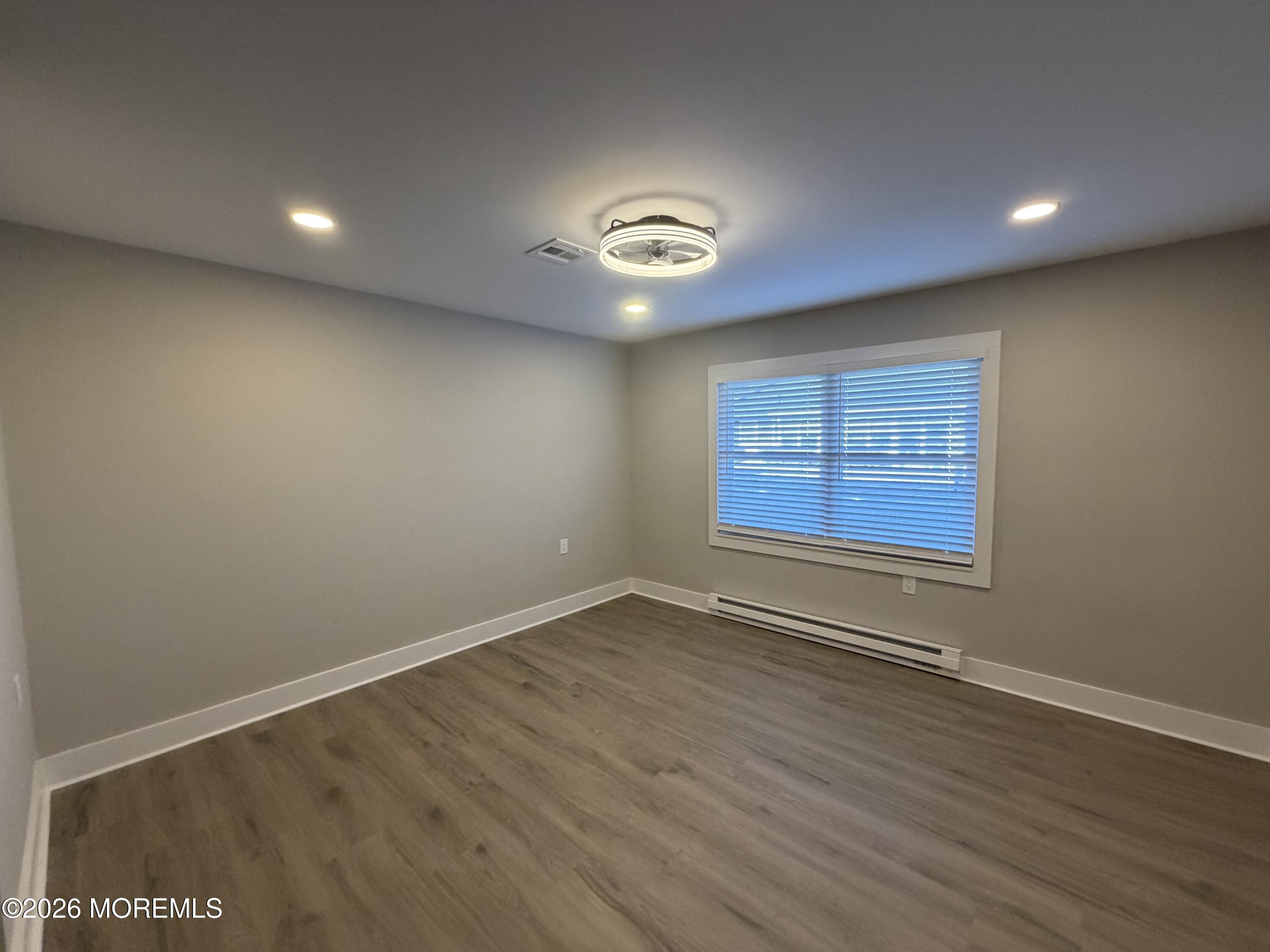833 B Inverness Court, Unit B Lakewood, NJ 08701 - Photo 31 of 43 an empty room with wooden floor and windows
