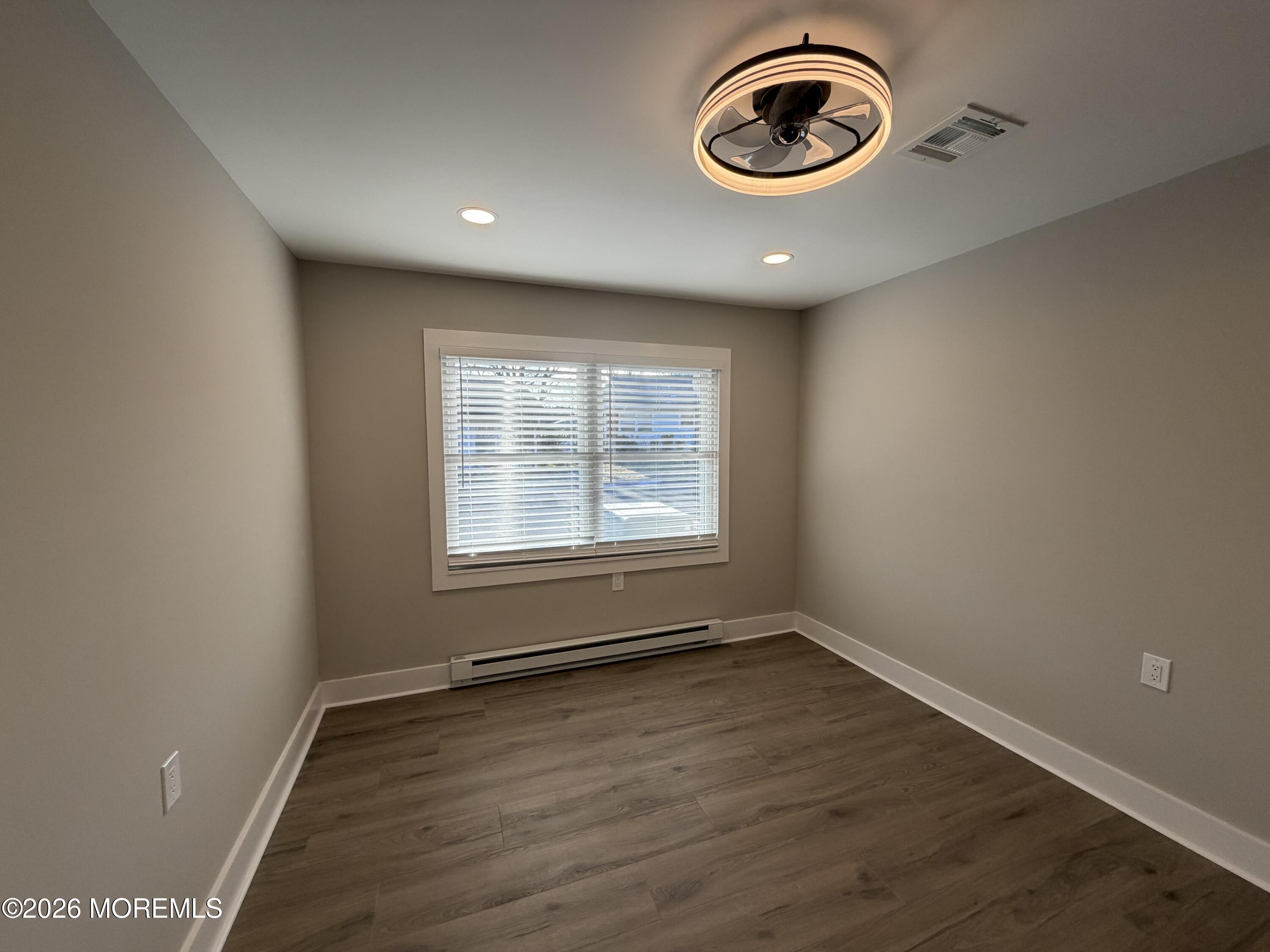 833 B Inverness Court, Unit B Lakewood, NJ 08701 - Photo 43 of 43 an empty room with wooden floor and window