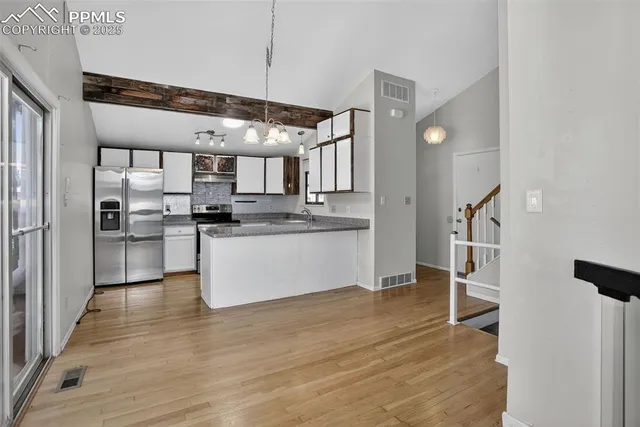a kitchen with stainless steel appliances granite countertop a refrigerator and a stove top oven