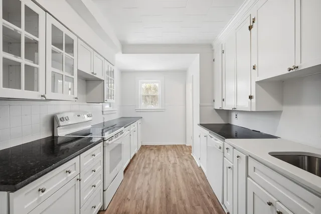 a kitchen with granite countertop a sink a counter space stainless steel appliances and cabinets
