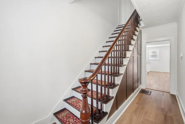 a view of staircase with wooden floor and white walls