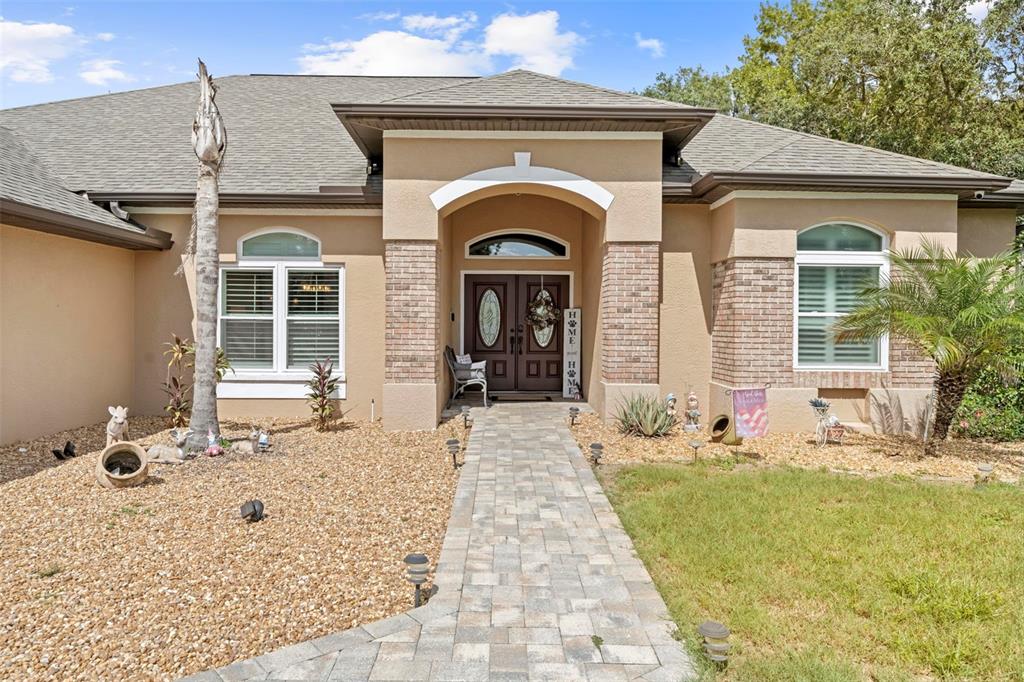 14173 Pullman Drive Spring Hill, FL 34609 - Photo 2 of 77 a front view of a house with garden
