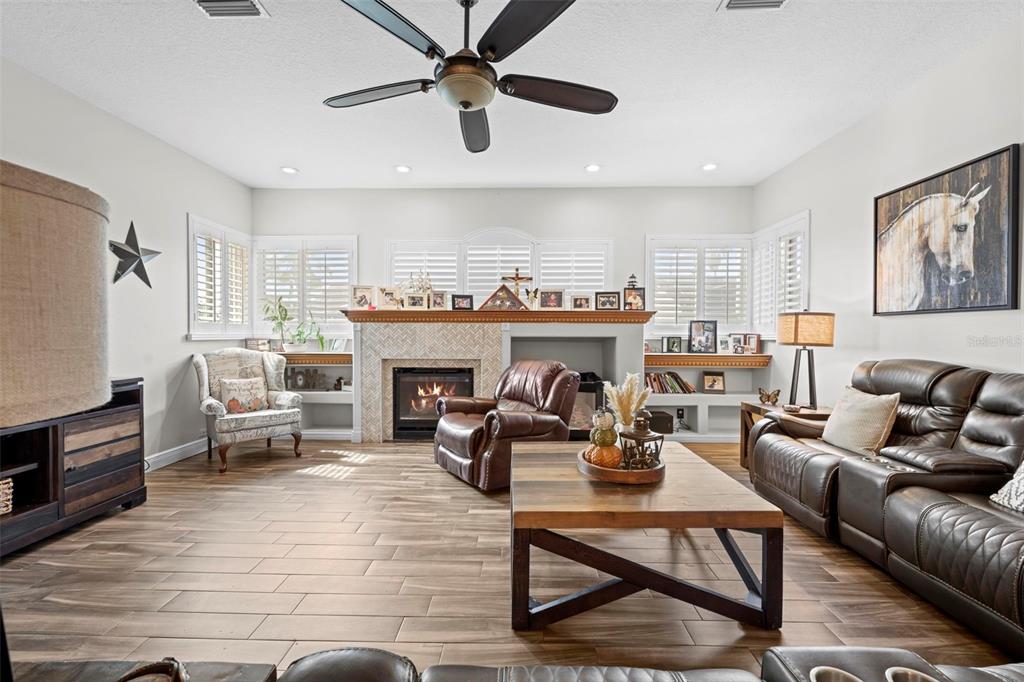 14173 Pullman Drive Spring Hill, FL 34609 - Photo 37 of 77 a living room with furniture a fireplace and a flat screen tv