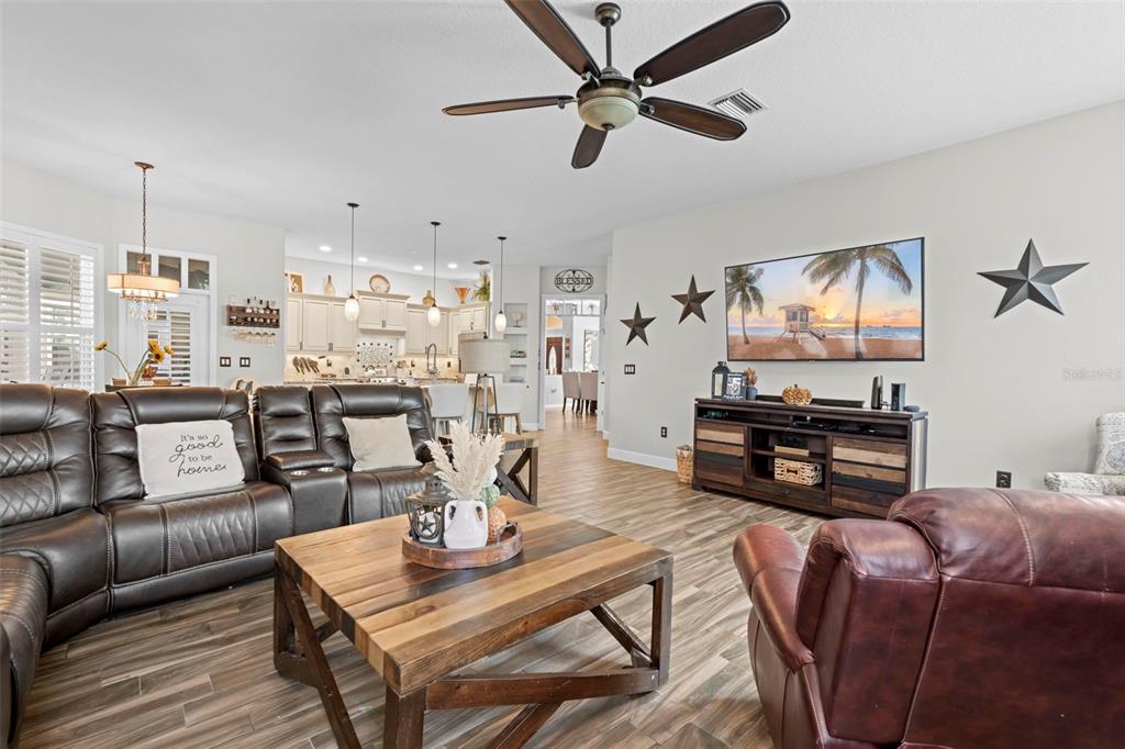 14173 Pullman Drive Spring Hill, FL 34609 - Photo 38 of 77 a living room with furniture and a flat screen tv with kitchen view