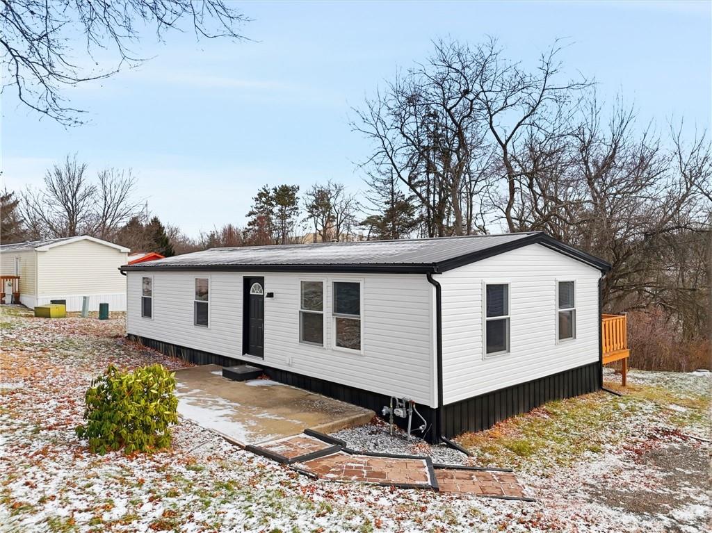 a view of a white house with a yard and large tree