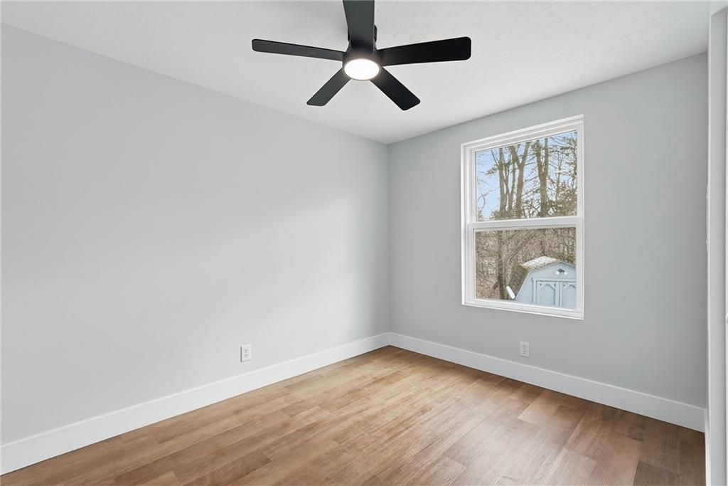105 York Road Cranberry Township, PA 16066 - Photo 10 of 18 an empty room with wooden floor ceiling fan and windows