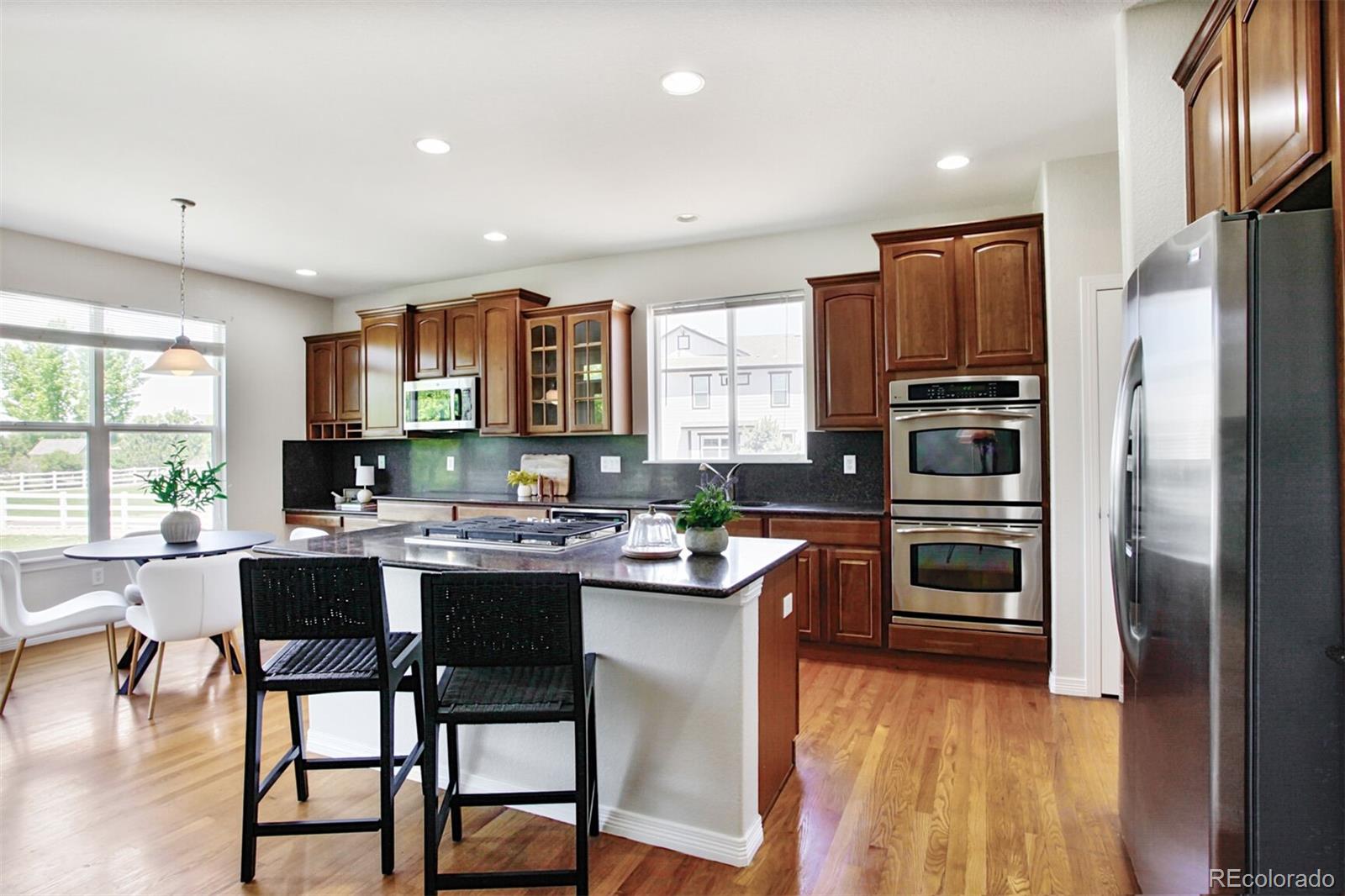 16283 Olive Way Brighton, CO 80602 - Photo 11 of 33 a kitchen with stainless steel appliances a stove a sink island and a refrigerator