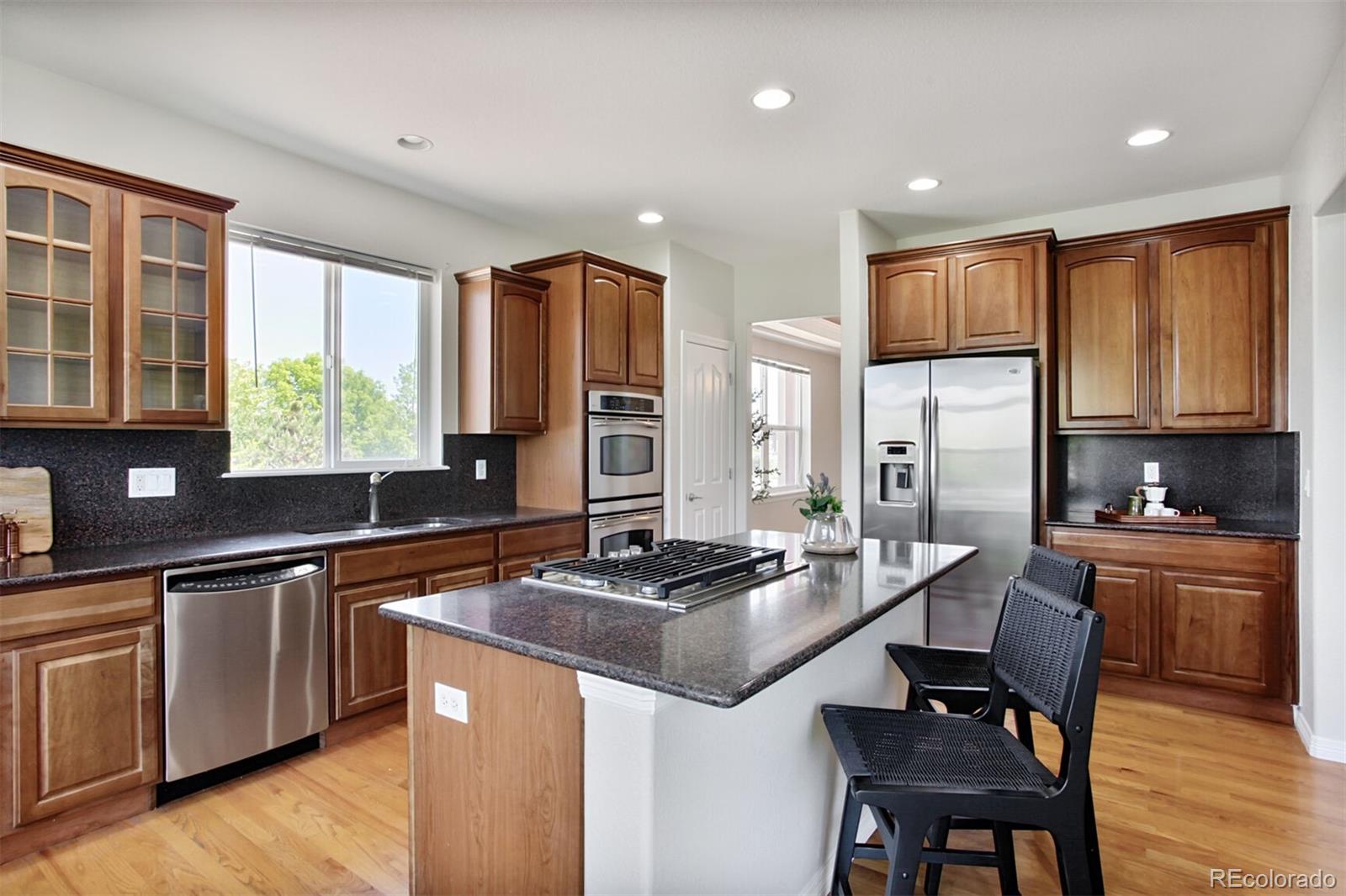 16283 Olive Way Brighton, CO 80602 - Photo 12 of 33 a kitchen with stainless steel appliances granite countertop a stove a sink a microwave a refrigerator and cabinets
