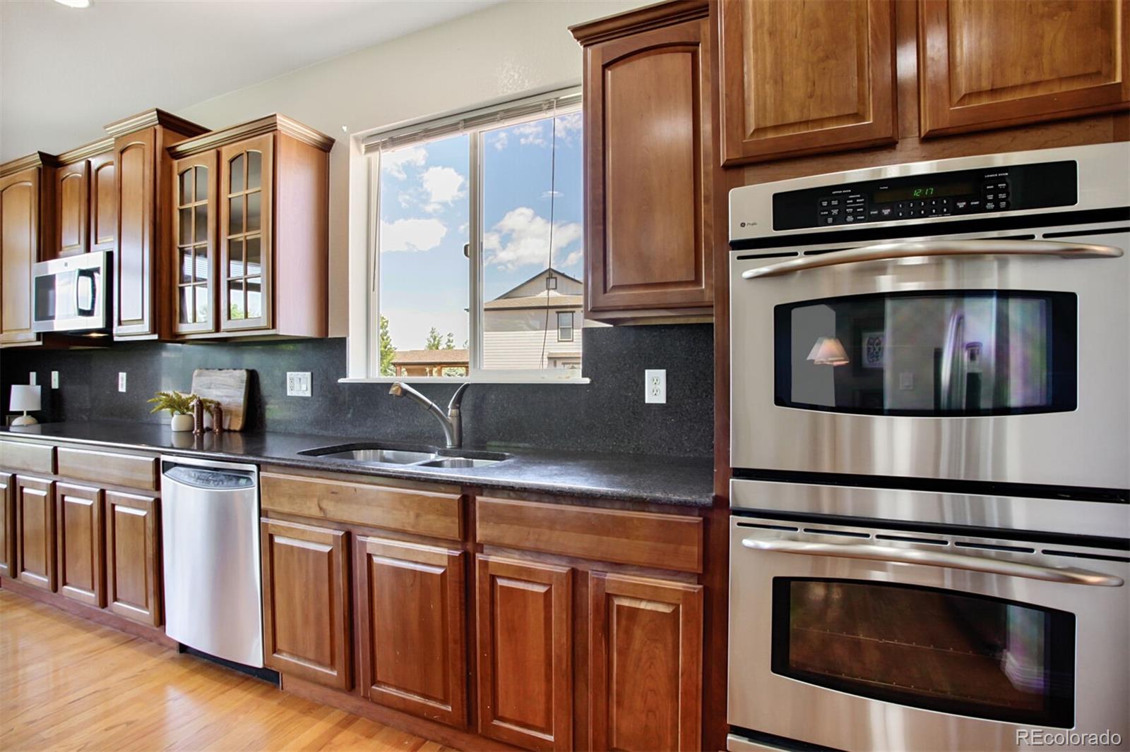 16283 Olive Way Brighton, CO 80602 - Photo 14 of 33 a kitchen with stainless steel appliances granite countertop a stove microwave and cabinets