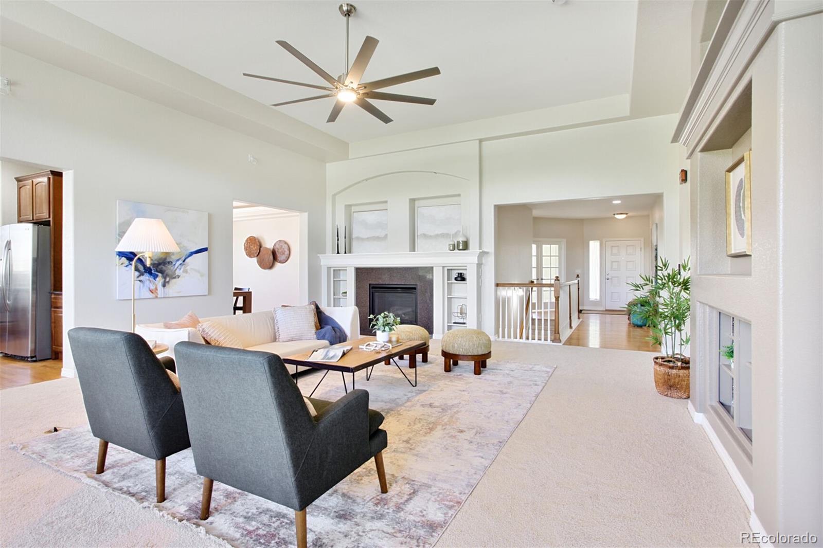16283 Olive Way Brighton, CO 80602 - Photo 8 of 33 a living room with furniture a fireplace and a chandelier