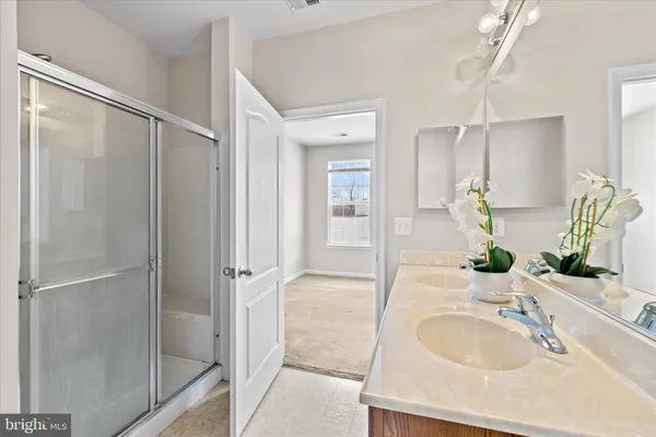 a bathroom with a granite countertop shower sink and mirror