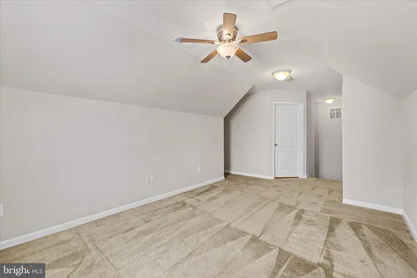 an empty room with ceiling fan and window