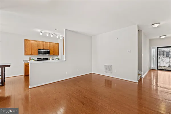 a view of a kitchen with wooden floor and electronic appliances