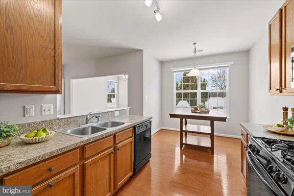 a kitchen with stainless steel appliances granite countertop a sink stove and cabinets