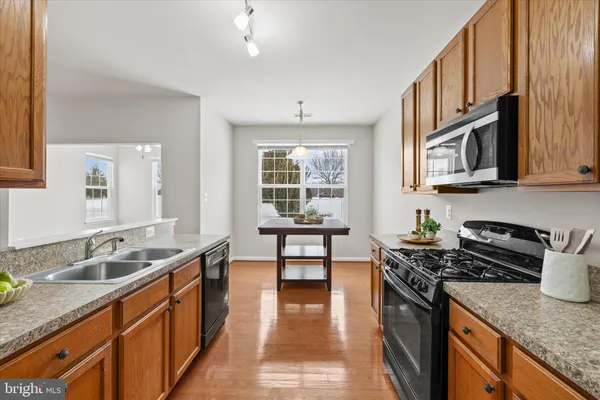 a kitchen with stainless steel appliances granite countertop a sink stove and cabinets