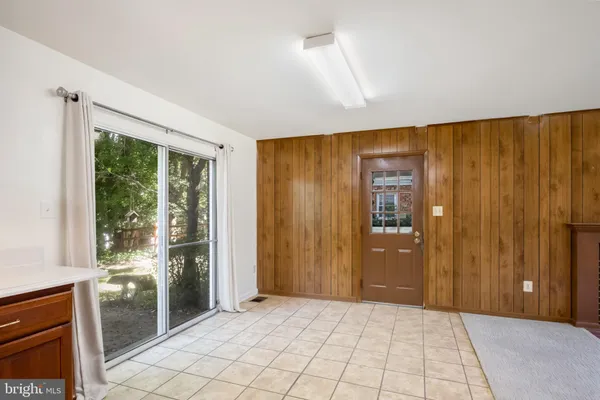 a view of an empty room with a fireplace and a window