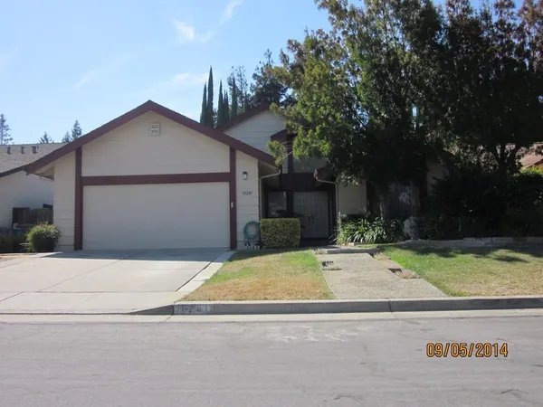 a view of the house with garage and plants