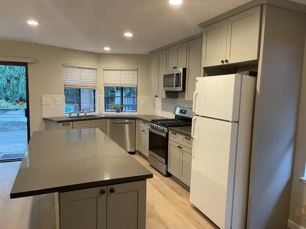 a kitchen with stainless steel appliances a refrigerator stove microwave and sink