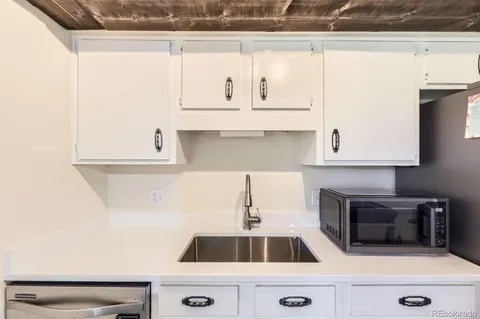 a kitchen with granite countertop white cabinets and white appliances