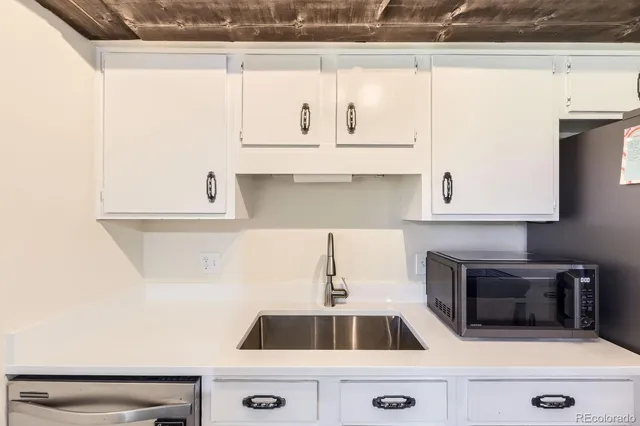 a kitchen with granite countertop white cabinets and white appliances